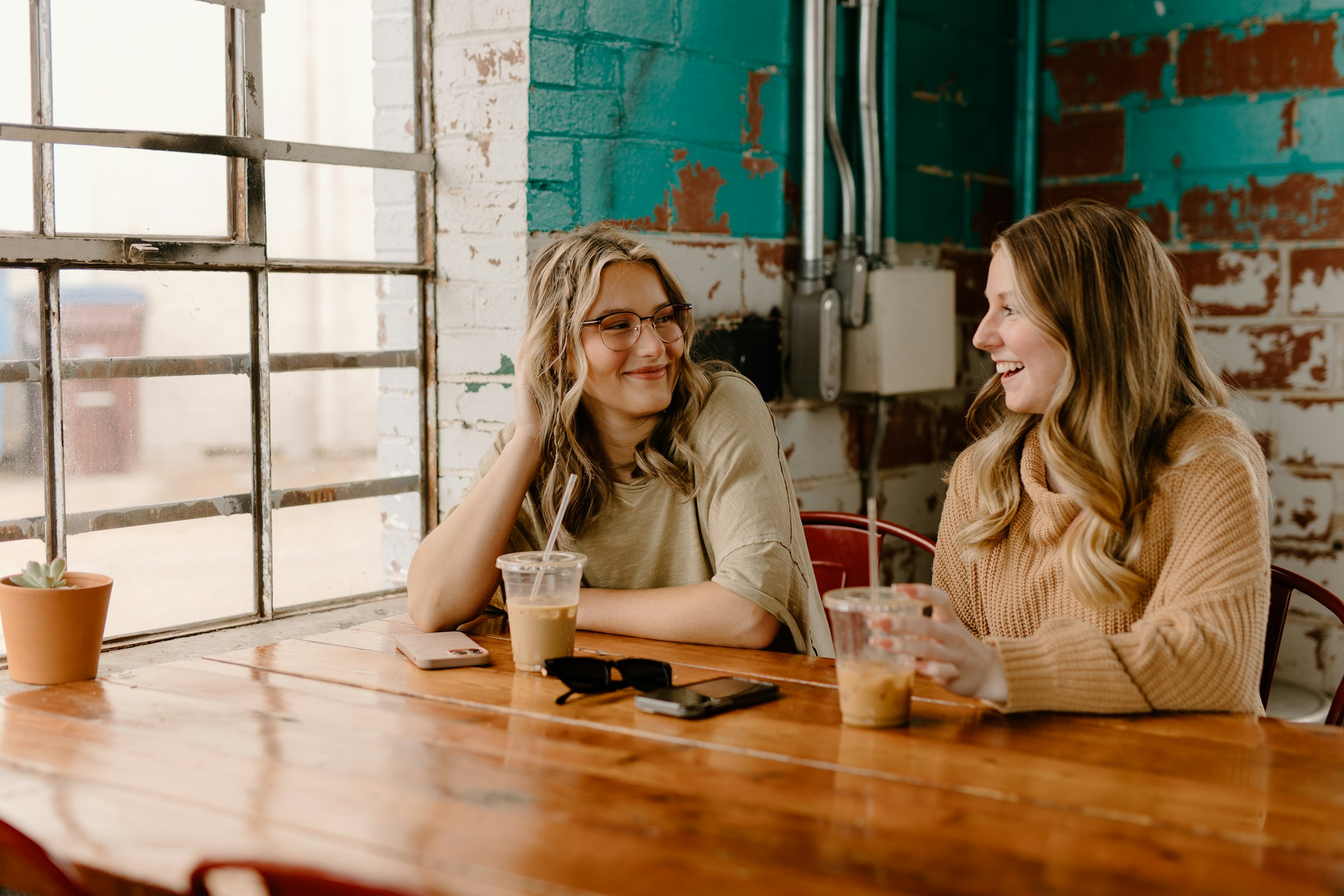 Two friends laughing together over coffee